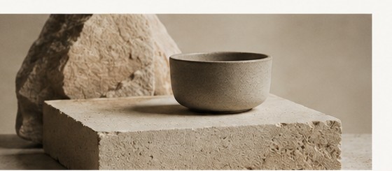 A ceramic bowl resting on a limestone block — quiet material craft.