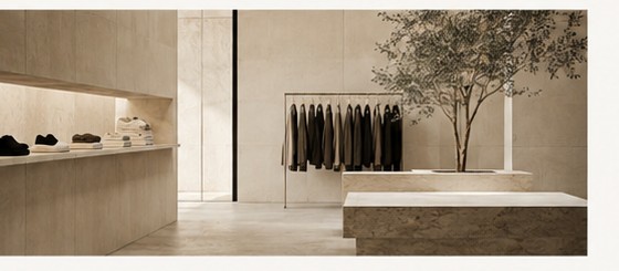 A calm retail interior with stone fixtures and an olive tree — scaled environment.